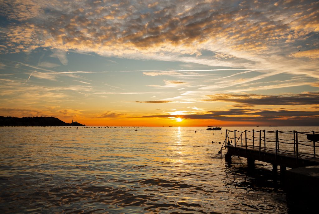 View of Saint George's Parish Church in Piran at sunset, seen from Strunjan, on the Adriatic Coast in Slovenia.