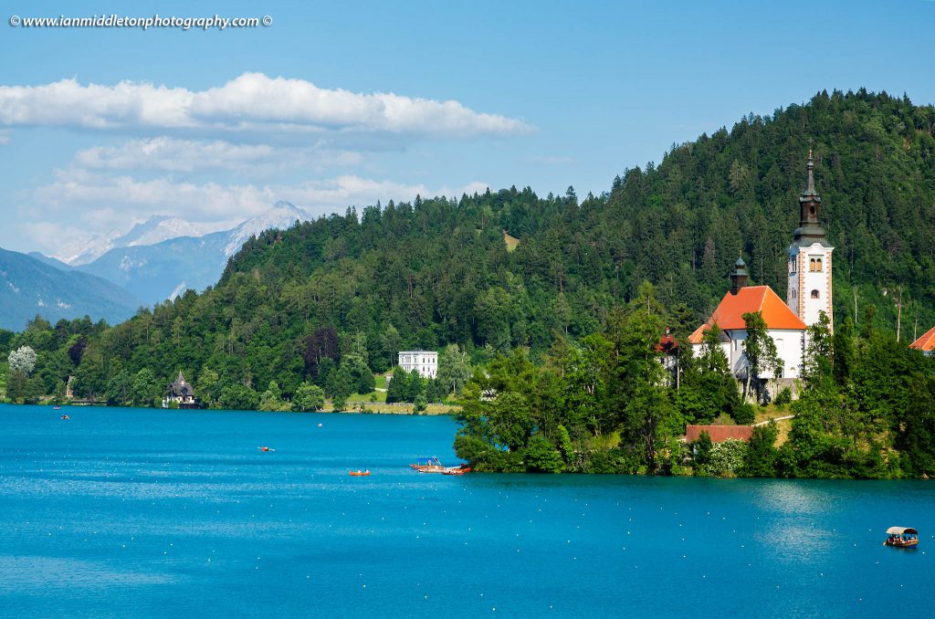 Late summer afternoon view across Lake Bled to the island church of the assumption of saint mary, Slovenia.